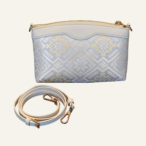 Four Swallows brocade-inspired phone crossbody bag with strap on warm neutral background
