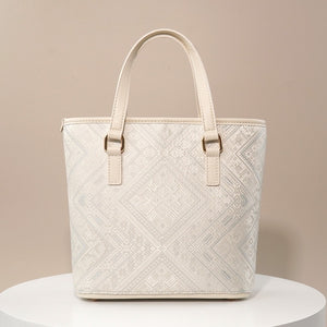 Ivory white geometric brocade-inspired mini tote bag on warm neutral background
