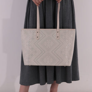 Model carrying ivory white brocade bag set