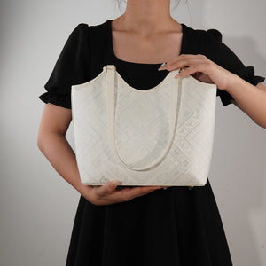 Model carrying ivory white brocade tote bag