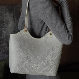 Model carrying ivory white brocade tote bag