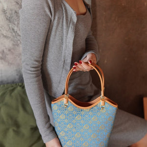 Model carrying royal blue brocade shoulder bag