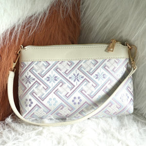 Silver lavender Wanjie brocade-inspired crossbody bag front view on soft neutral texture