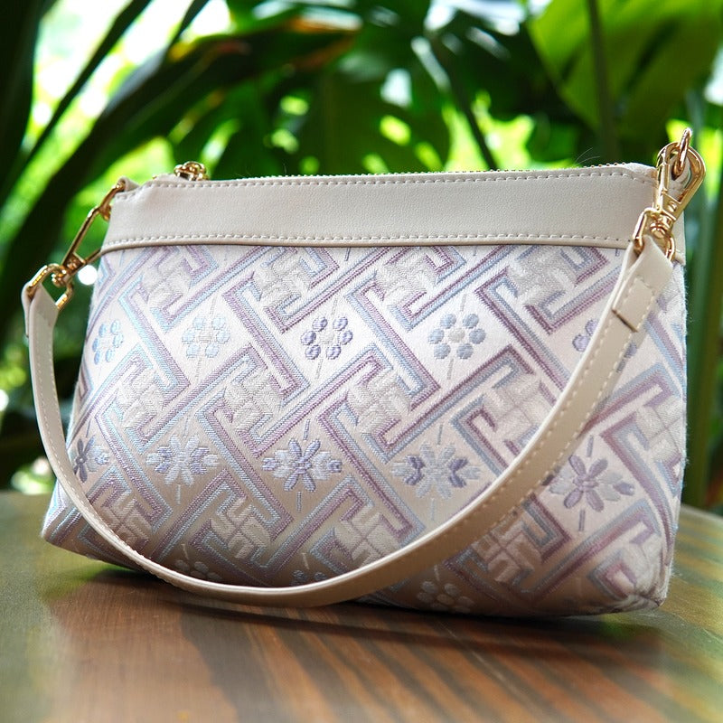 Silver lavender Wanjie crossbody bag angled front view on wood table