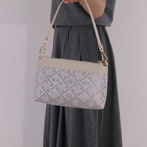 Model hand carrying silver lavender Wanjie brocade-inspired crossbody bag