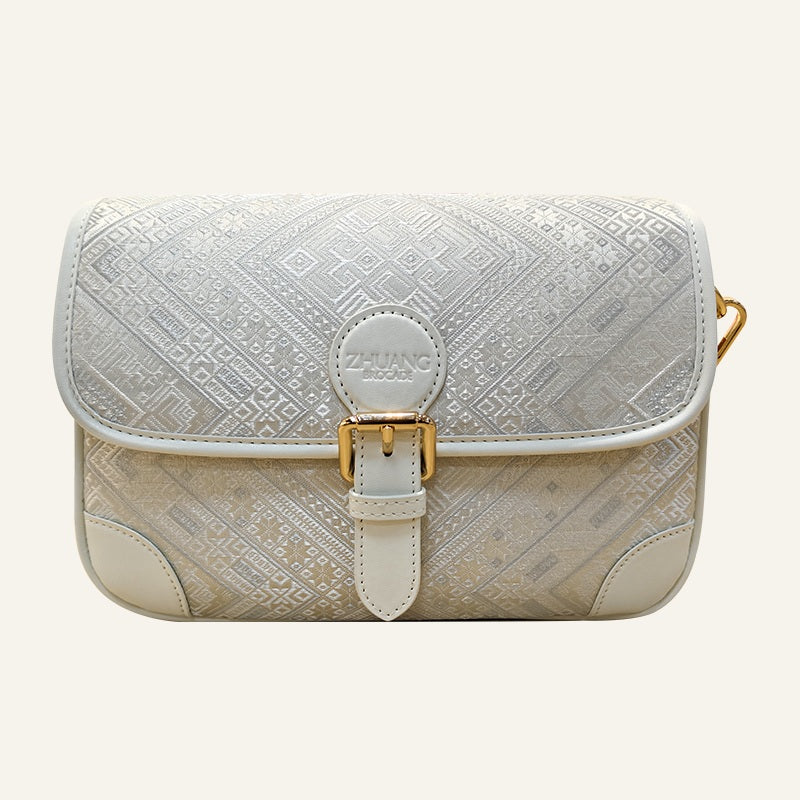 Ivory geometric brocade-inspired baguette bag front view on warm neutral background