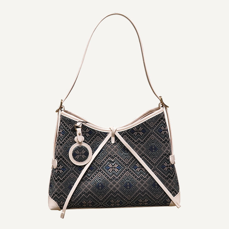 Deep blue butterfly flower brocade-inspired drawstring shoulder bag front view on warm neutral background