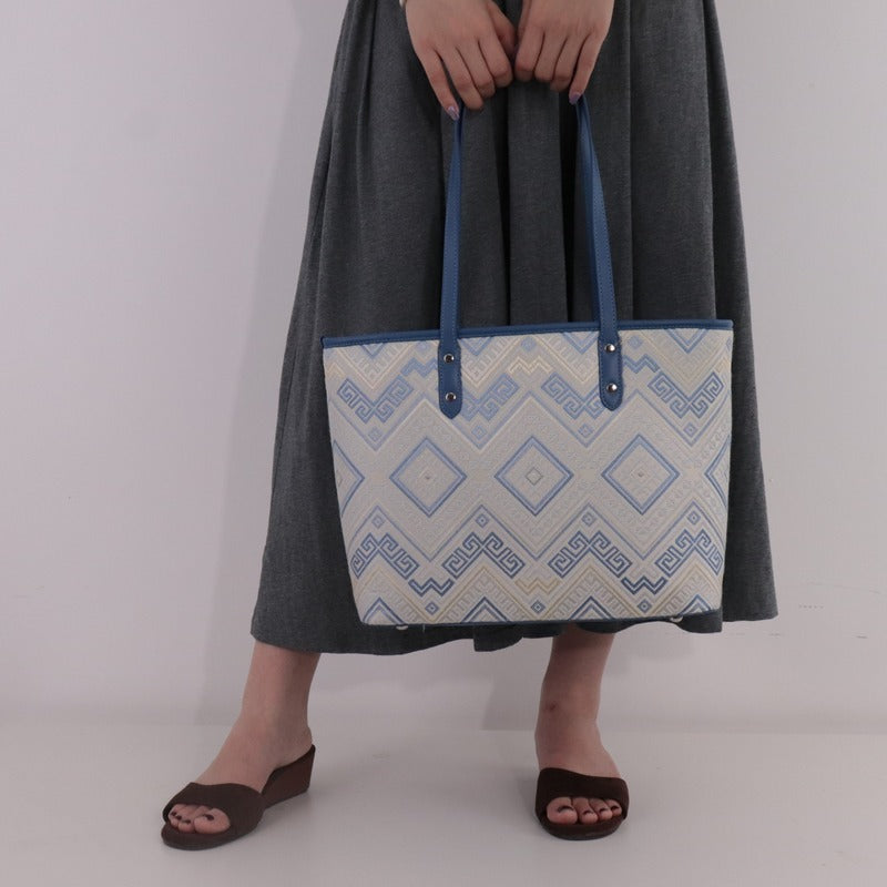 Model carrying blue white brocade tote bag