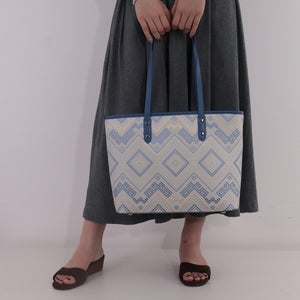 Model carrying blue white brocade tote bag