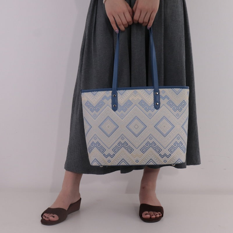 Model carrying blue white brocade tote bag