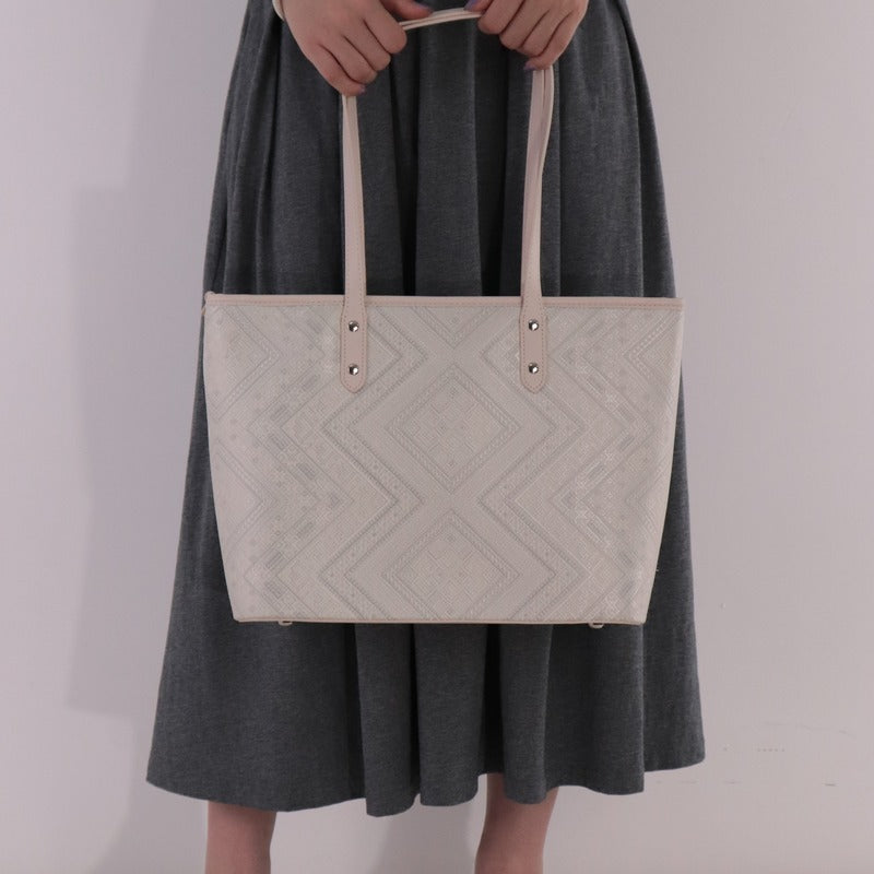 Model carrying ivory white brocade bag set