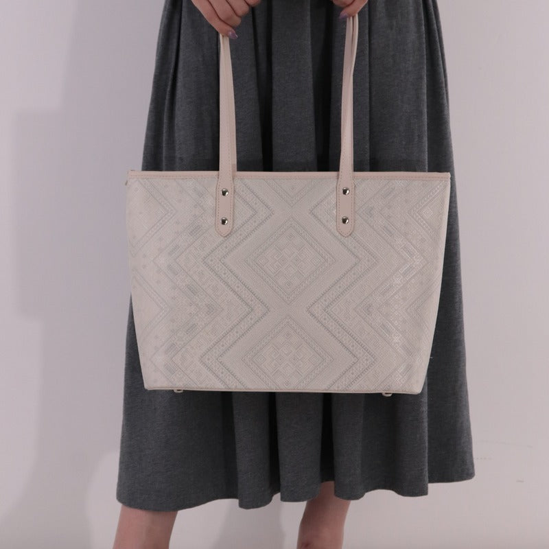 Model carrying ivory white brocade bag set