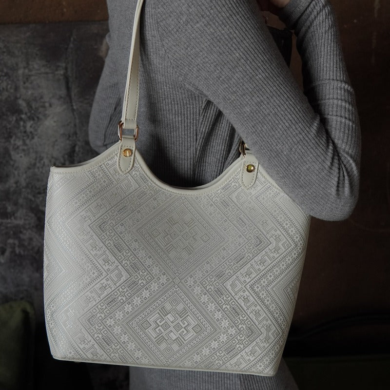Model carrying ivory white brocade tote bag