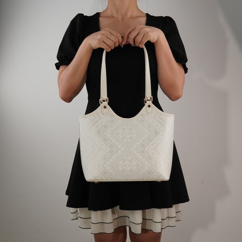 Model carrying ivory white brocade tote bag