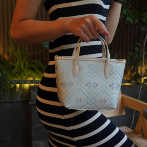 Model carrying multicolor brocade crossbody bag