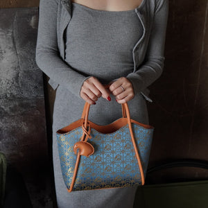 Model carrying multicolor brocade shoulder bag
