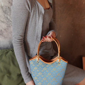 Model carrying royal blue brocade shoulder bag